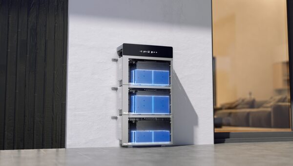 A Hoymiles HiBattery stack of three wall-mounted home battery modules with a control unit, installed on a wall beside a doorway