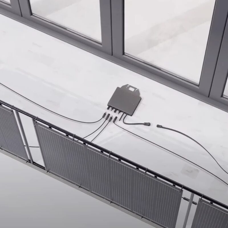 A 3D render of a plug-in balcony solar kit with panels hung on a balcony railing and a micro-inverter and cables on the floor