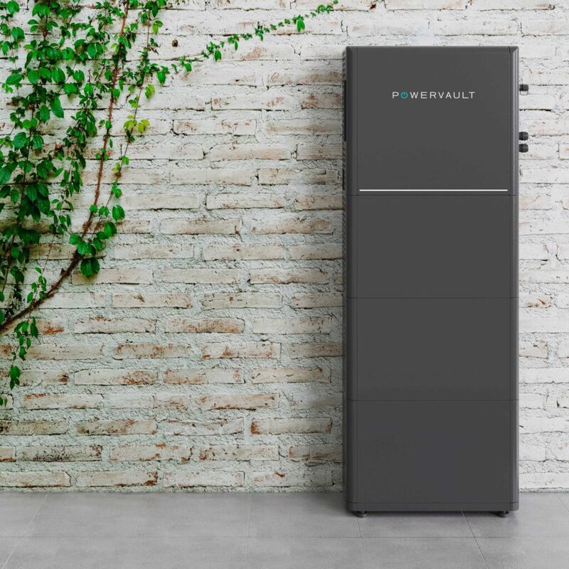 A tall grey Powervault P5 home battery storage unit standing against a white brick wall with climbing ivy