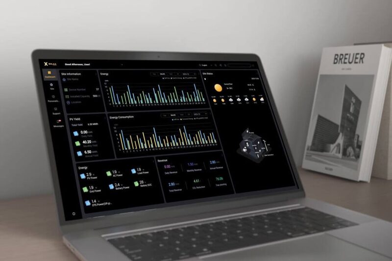 A laptop displaying the SolaX solar monitoring dashboard with energy charts and site statistics