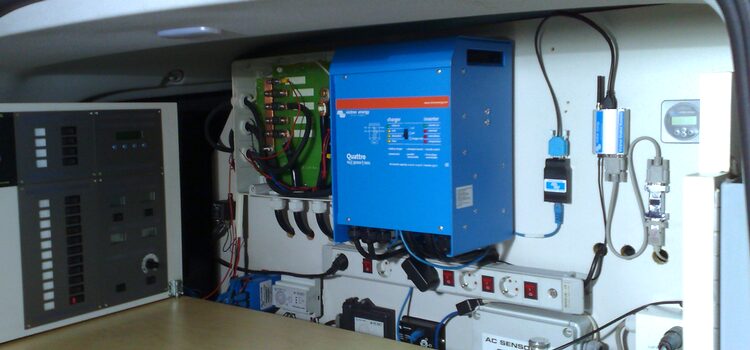 A blue Victron Quattro inverter installed in a compact electrical enclosure with wiring, breakers and control panels