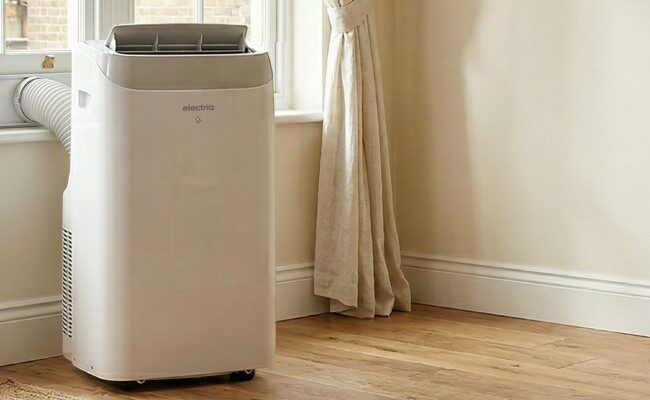 A white Electriq portable air conditioner with an exhaust hose out of a window in a home room