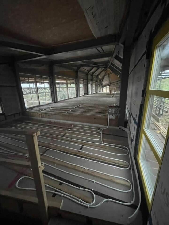 Underfloor heating pipes being laid across the floor of a building under construction