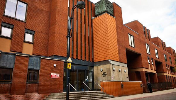 The red-brick exterior of Leeds Civic Hall-style council building with an orange tiled entrance tower and street lamp in front