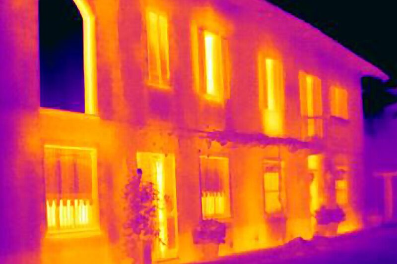 Thermal image of a house showing heat loss through windows and walls