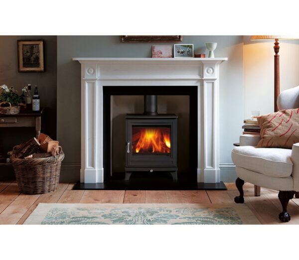 A black wood-burning stove with flames burning inside a white fireplace surround in a living room
