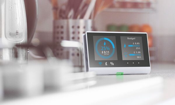A smart meter display showing energy usage and budget figures sitting on a kitchen worktop
