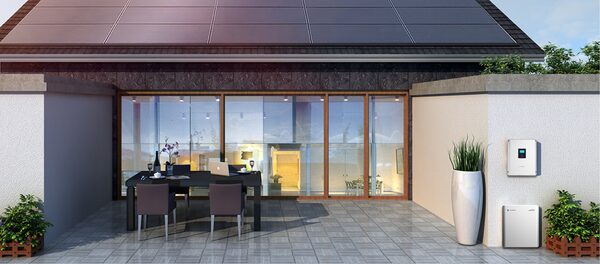 A modern house with rooftop solar panels and a Sungrow inverter and battery unit mounted on the patio wall