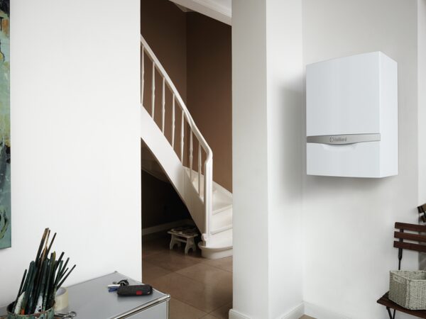 A white Vaillant ecoTEC plus wall-mounted gas boiler installed in a home hallway beside a staircase