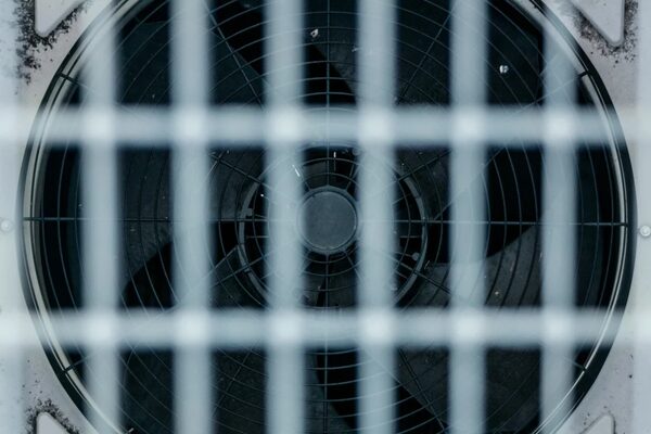 A close-up of an extractor ventilation fan behind a white grille