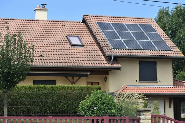 A house with a large solar panel array on its tiled roof