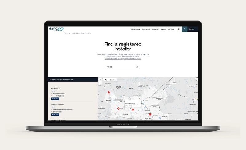A laptop displaying the Sync Energy 'Find a registered installer' webpage with a postcode search box, installer listings and a map with location pins