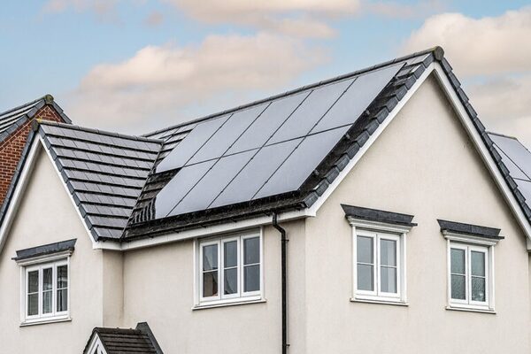 Solar panels fitted on the tiled roof of a cream-coloured UK house