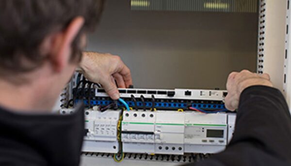 An electrician installing a Schneider Electric smart electrical panel and wiring in a consumer unit