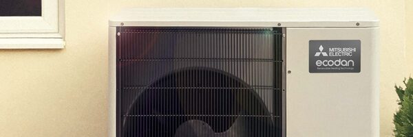 A Mitsubishi Electric Ecodan air source heat pump unit installed outside a house wall in sunlight
