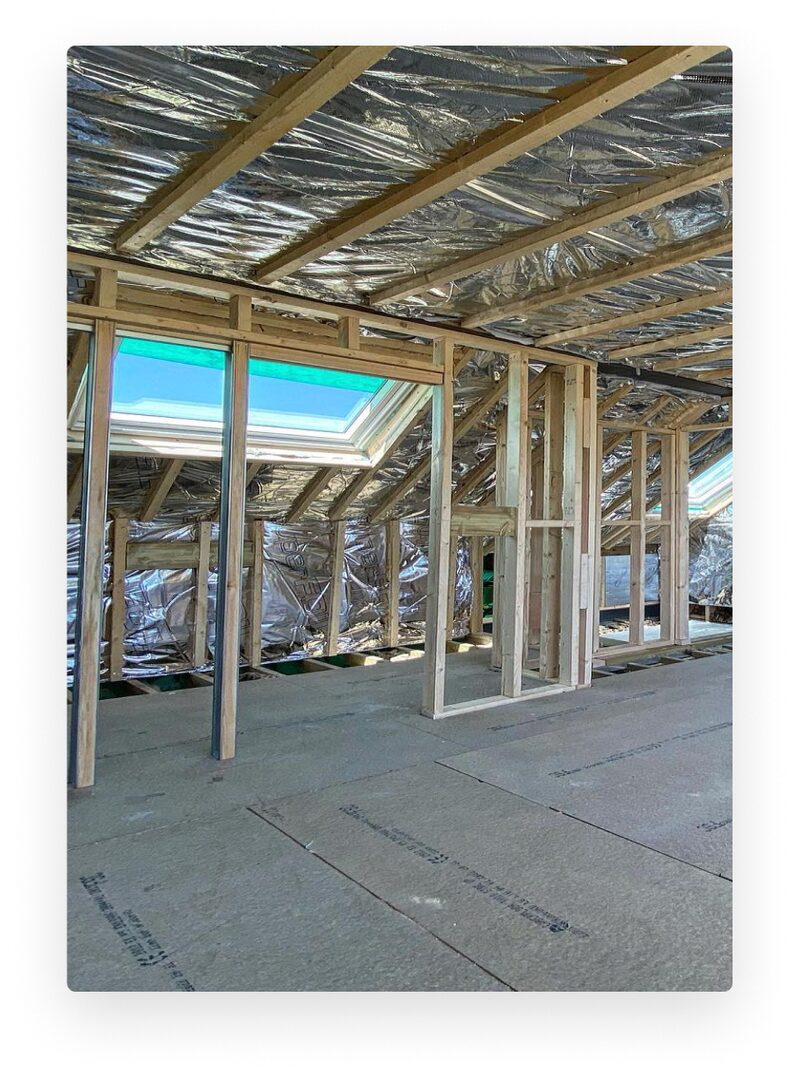 A loft conversion under construction with reflective foil insulation fitted between the roof rafters and stud walls