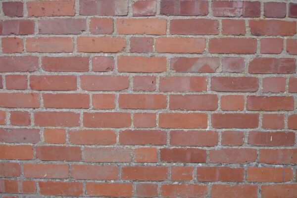 A close-up of a red brick wall with visible mortar joints