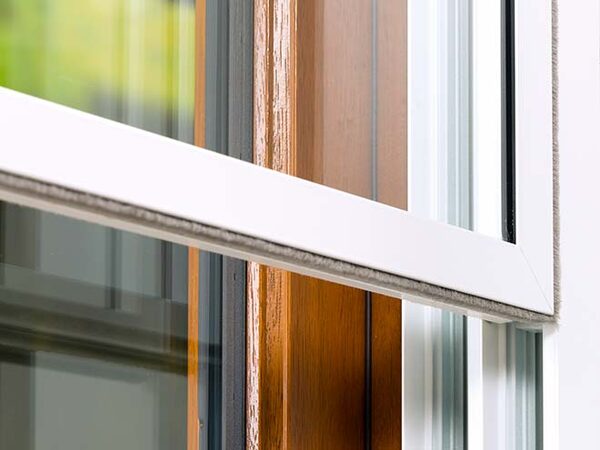 Close-up of a white secondary glazing panel fitted inside a wooden window frame