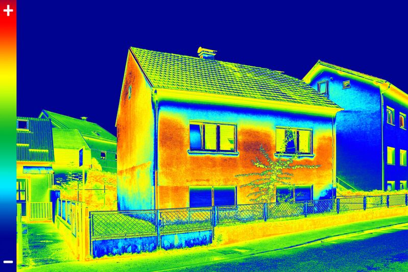 Thermal image of a detached house showing heat loss through its walls and roof