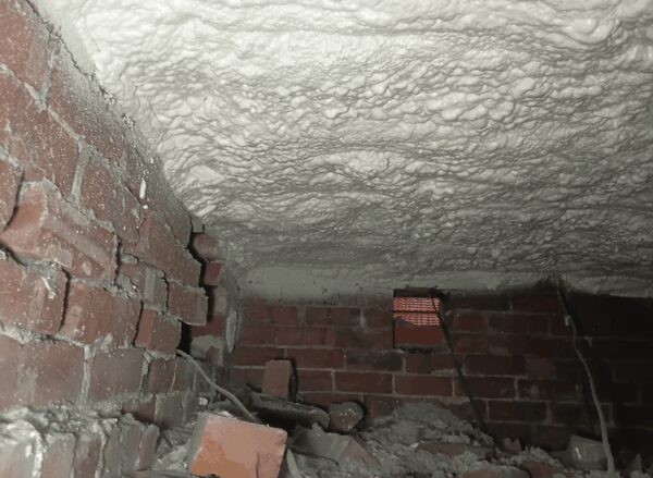 Spray foam insulation applied to the underside of a timber floor above a brick crawl space