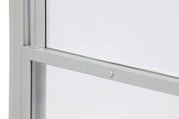 Close-up of a white vertical sliding secondary glazing panel frame with a tilt-in catch