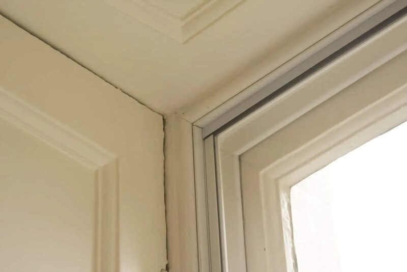 A close-up of secondary glazing fitted inside a white window reveal in a home