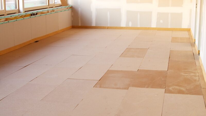 A room with wood fibre insulation boards being laid across the floor during renovation