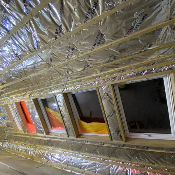 SuperFOIL SF19+ multifoil insulation installed between timber battens on a sloped roof above windows