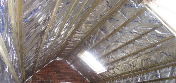 Reflective foil insulation (SuperFOIL SF19) fitted between roof rafters in a loft with a skylight