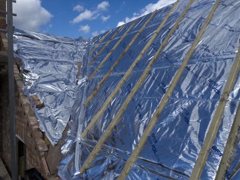 SuperFOIL SF19 multifoil insulation being installed over a roof structure with timber battens