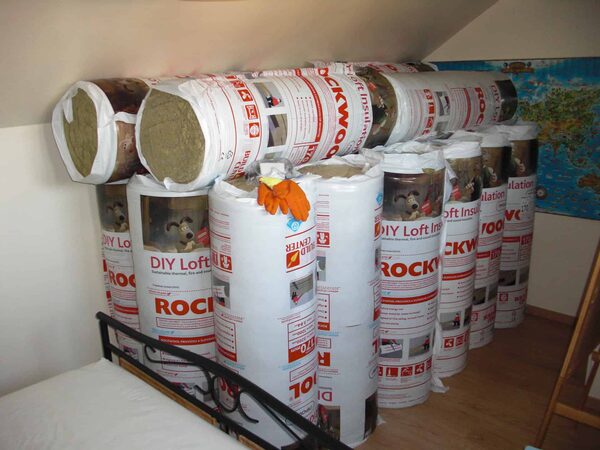 A stack of Rockwool DIY loft insulation rolls stored in a loft room