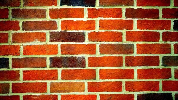 A close-up of a red brick wall with pale mortar joints