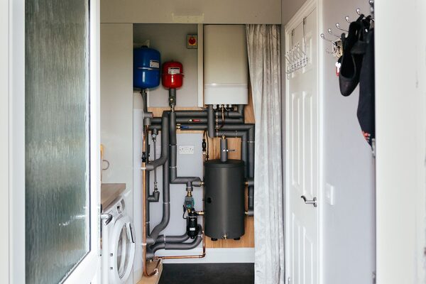 An Aira heat pump installation with cylinder, expansion vessels and pipework in a home airing cupboard