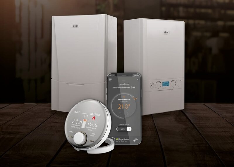 Two white Ideal combi boilers displayed with a round Halo smart thermostat and a smartphone showing a heating control app