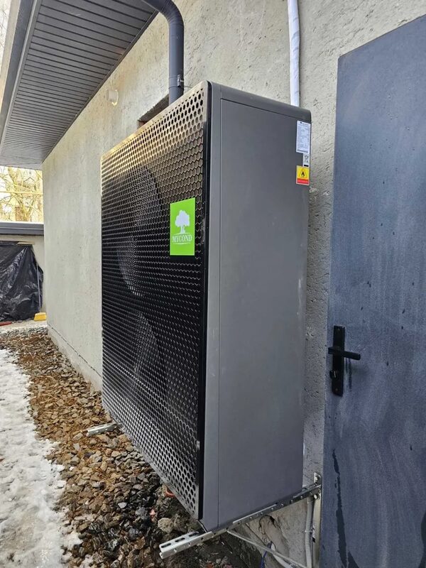 A Mycond air source heat pump unit installed on the exterior wall of a house