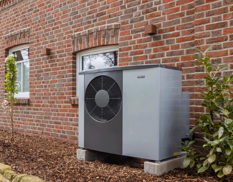 A NIBE air source heat pump unit installed outside a red brick house