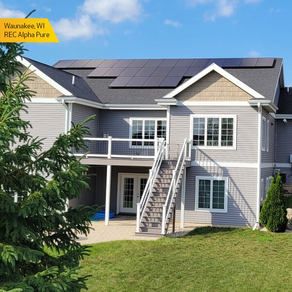 A large grey American house with REC Alpha Pure solar panels installed on its roof