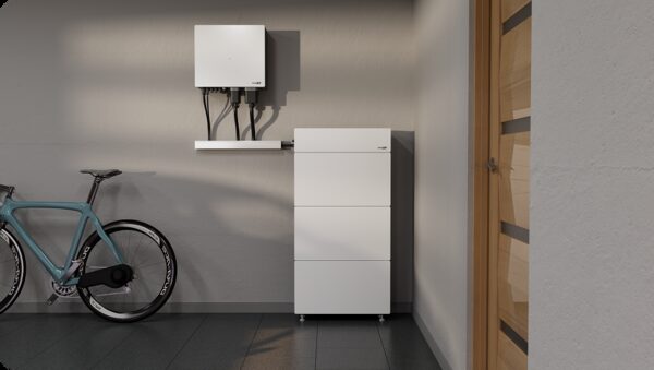 A white SolarEdge home battery unit and wall-mounted inverter installed in a garage next to a bicycle