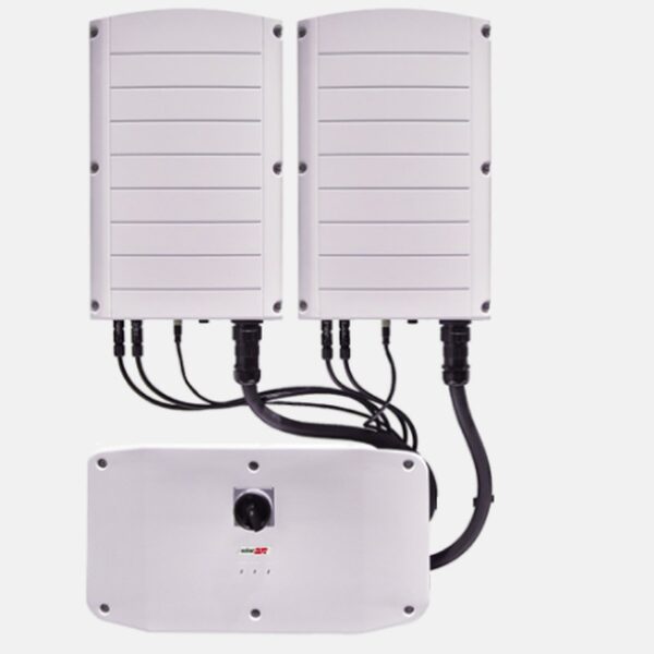 Two white SolarEdge three-phase solar inverters mounted above a Synergy Manager unit with cabling between them