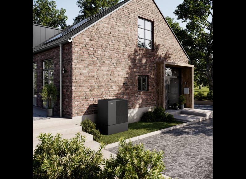 A Stiebel Eltron air source heat pump unit installed outside a brick house