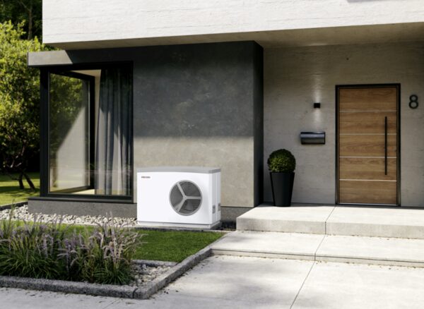 A Stiebel Eltron air source heat pump unit installed outside a modern house beside the front door