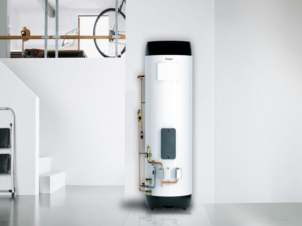 A Vaillant uniSTOR hot water cylinder installed against a white wall in a modern home, with copper pipework and valves attached