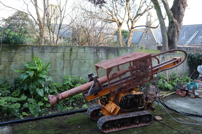 A tracked drilling rig in a garden being used to bore a ground loop for a ground source heat pump installation