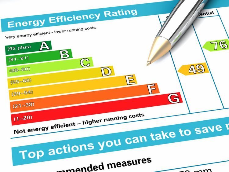An energy performance certificate chart showing the A to G energy efficiency rating scale with a pen resting on it
