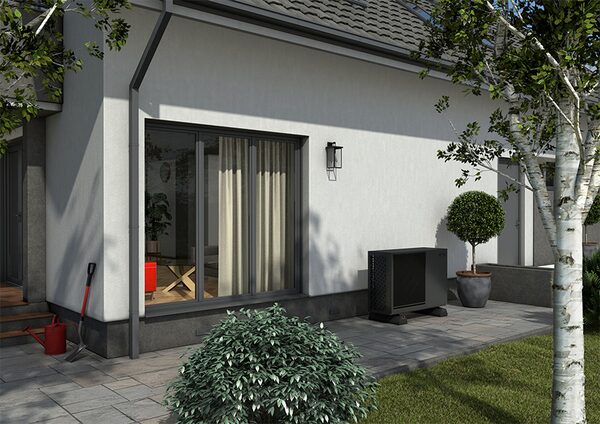 A Grant air source heat pump unit installed on a paved patio beside the exterior wall of a modern house