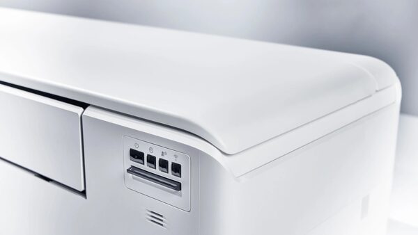 Close-up of a white Daikin air-to-air heat pump indoor unit showing its control panel