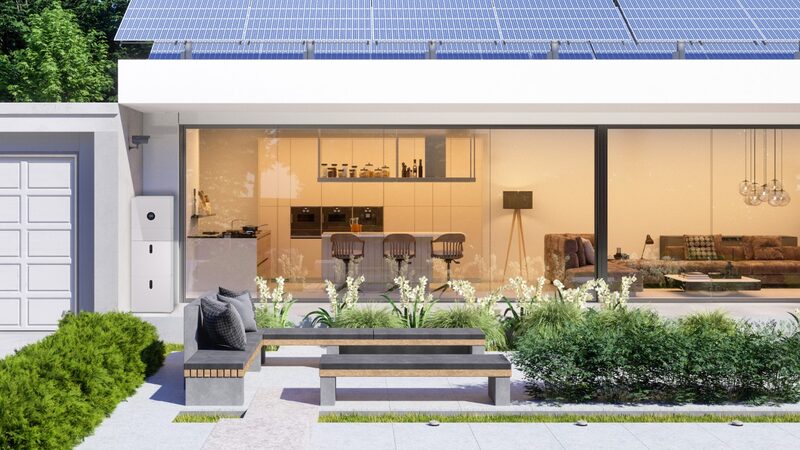 A modern house with rooftop solar panels and a white battery storage unit mounted on the exterior wall beside the garage