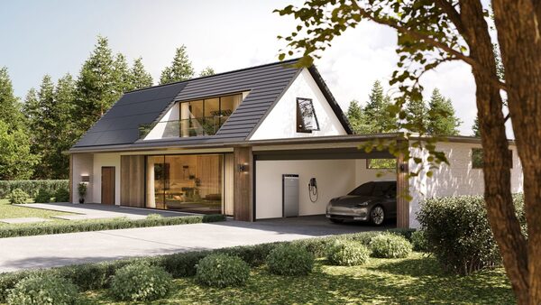 A modern house with solar panels on the roof and a home battery unit with EV charger in the open garage where a car is parked