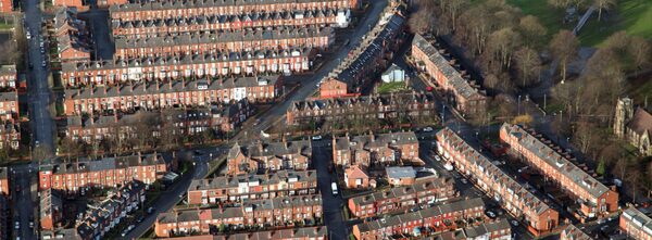 An aerial view of rows of red-brick terraced houses in a UK residential neighbourhood