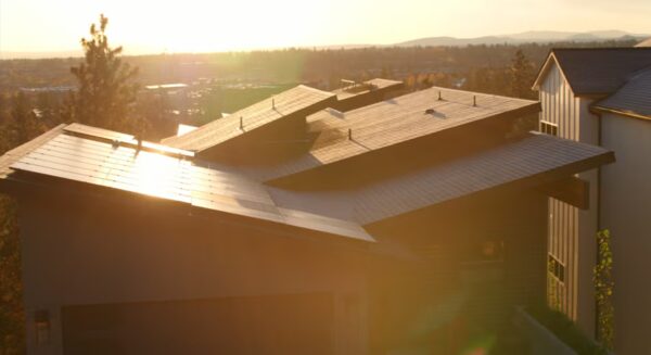 A modern house with rooftop solar panels at sunset